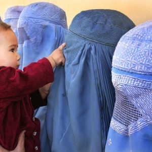 A group of women club in burqas waiting in the Dashti Barchi Clinic in Kabul to have their children vaccinated, Sep 28, 2004. Photo by Farzana Wahidy